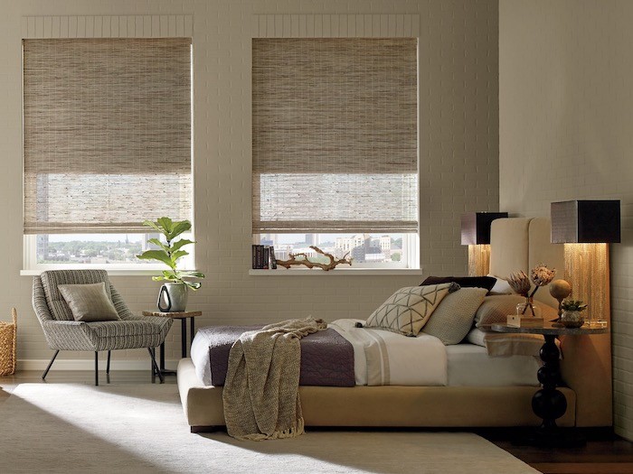 A bedroom with woven wood shades.